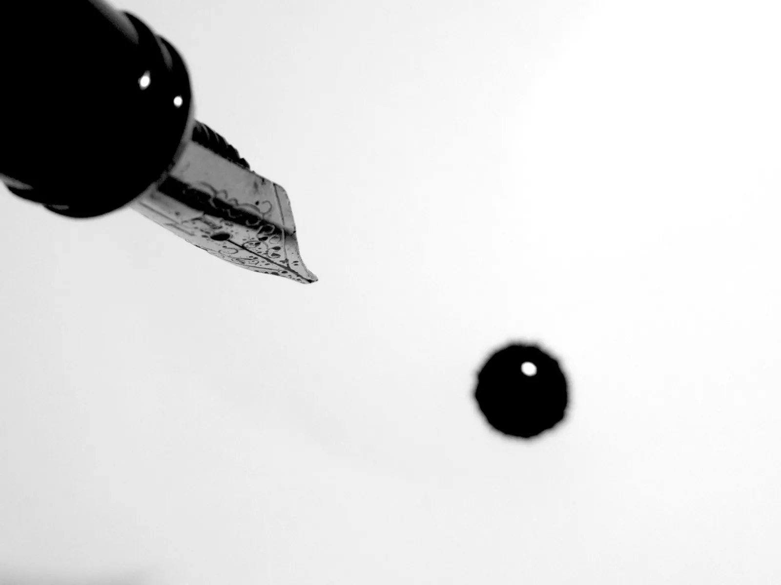 Fountain pen nib dripping a drop of ink